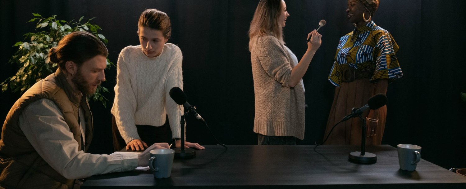 Et lille hold øver et interview, mens en underviser følger med fra siden.